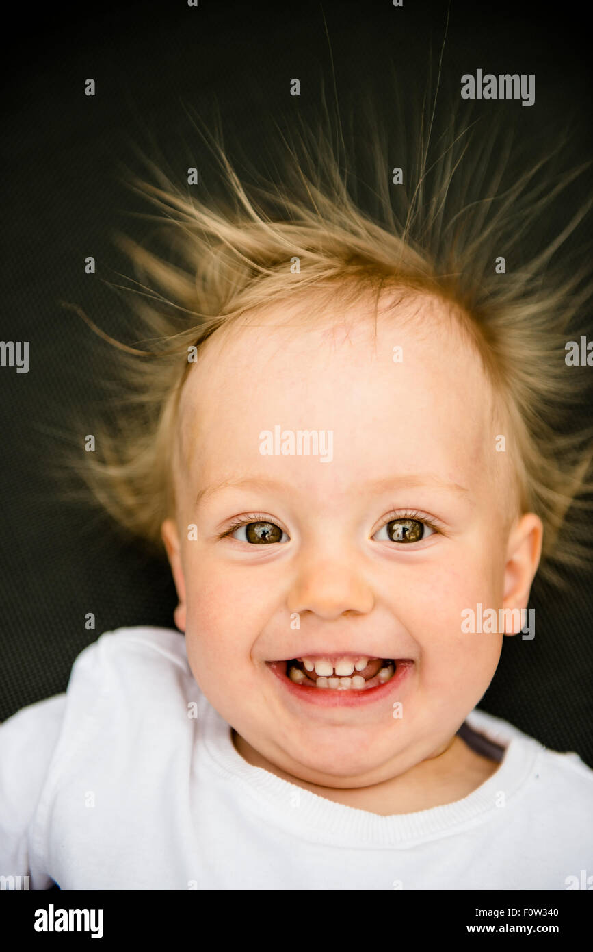 Portrait of smiling baby with standing hair from static electricity Stock Photo