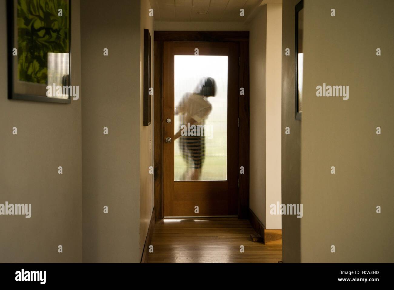Silhouette of businesswoman closing front door Stock Photo