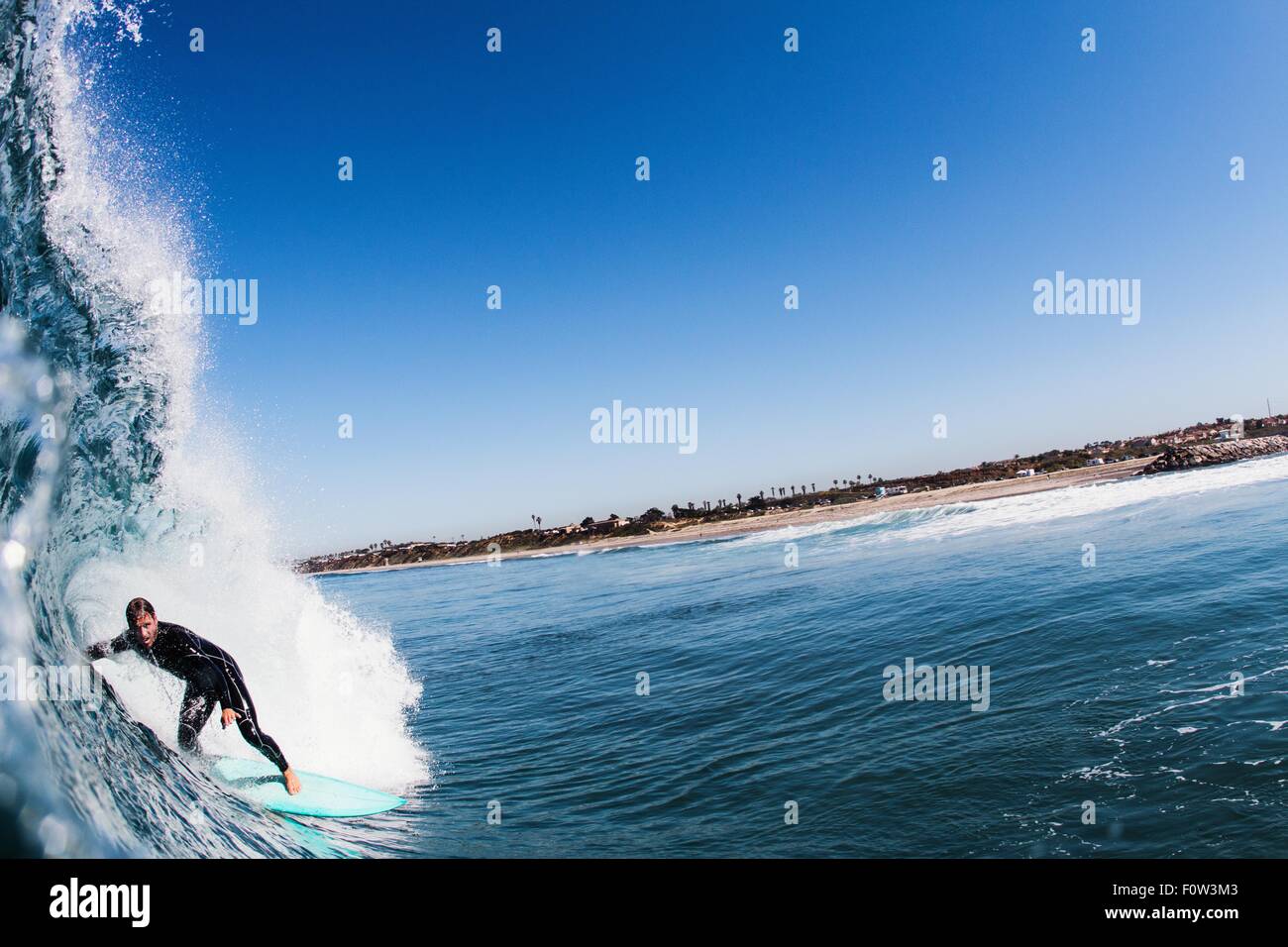 Close up of ocean wave and mid adult man surfing, Carlsbad, California, USA Stock Photo