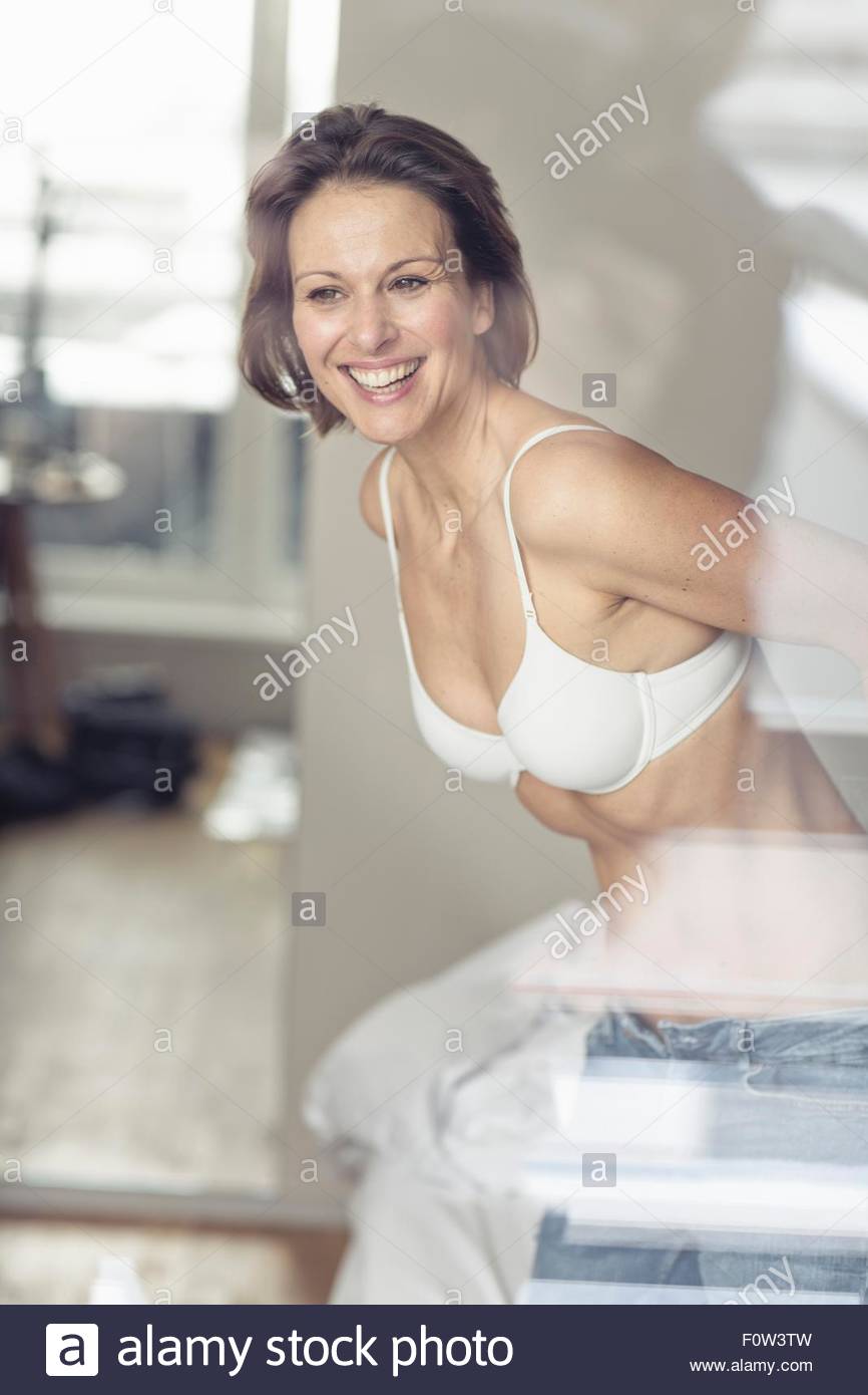 Mature Woman Wearing Bra Putting On Jeans Stock Photo Alamy
