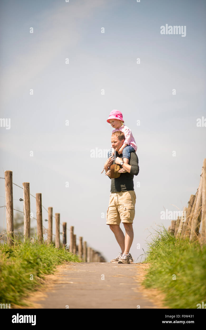 Dad carrying Daughter on walk together. Stock Photo