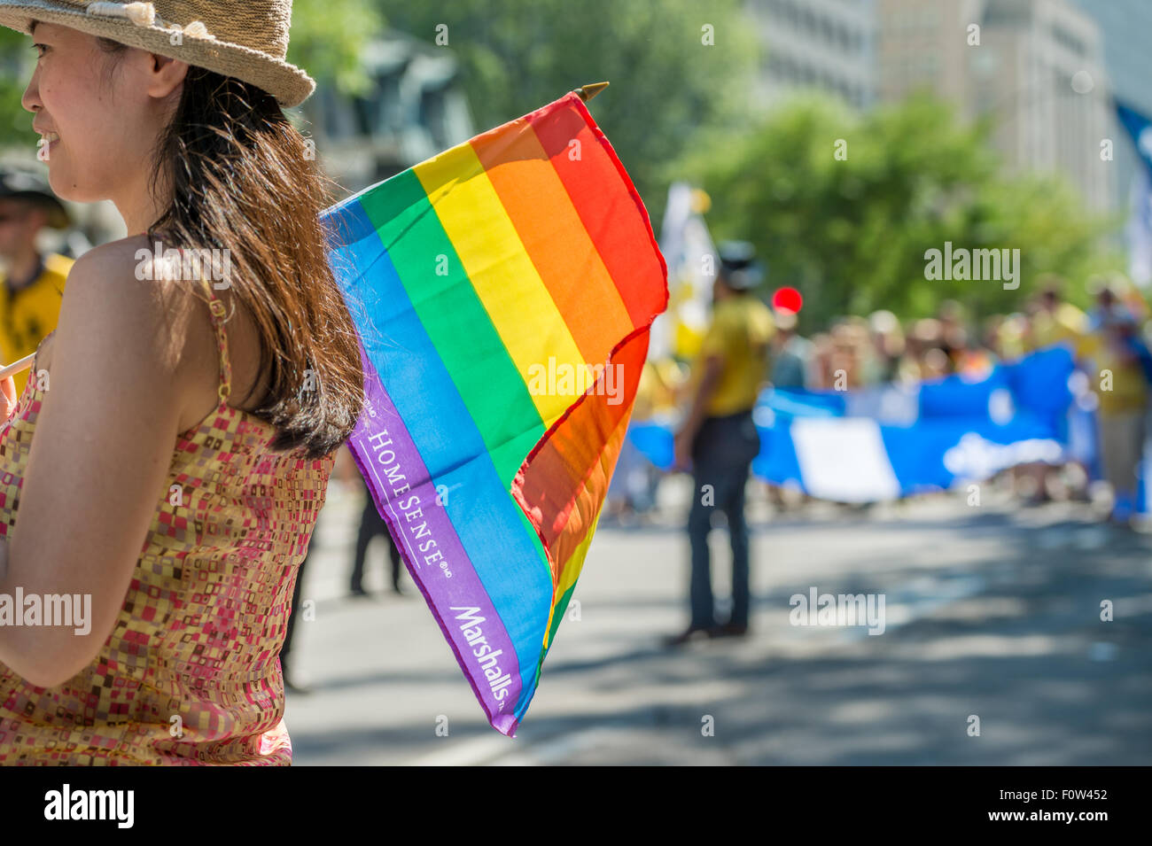 Gay Pride spectators carrying Rainbow gay flags during Montreal Pride March Stock Photo