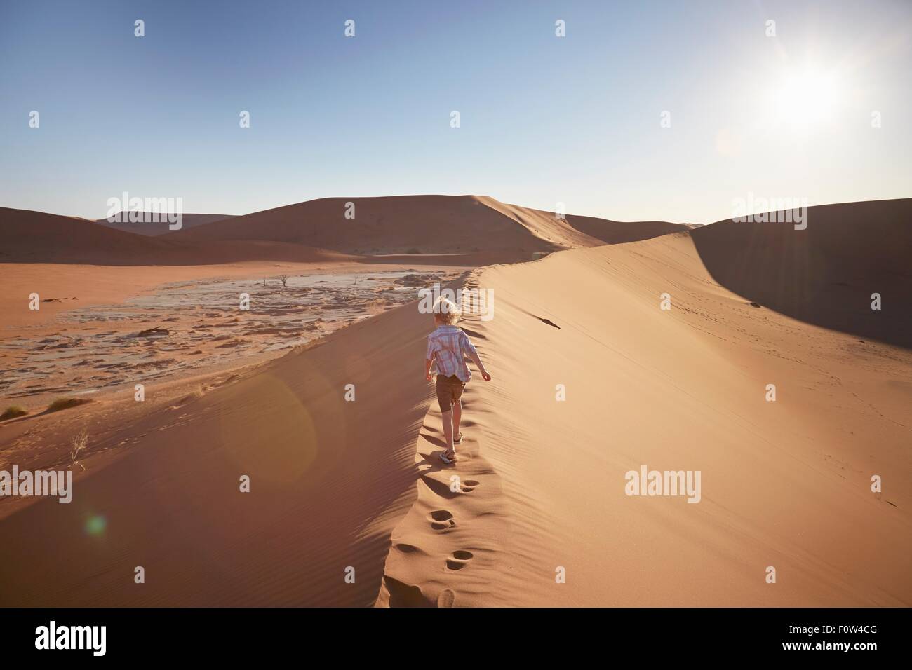 Boy walking on sand dune, Namib Naukluft National Park, Namib Desert, Sossusvlei, Dead Vlei, Africa Stock Photo