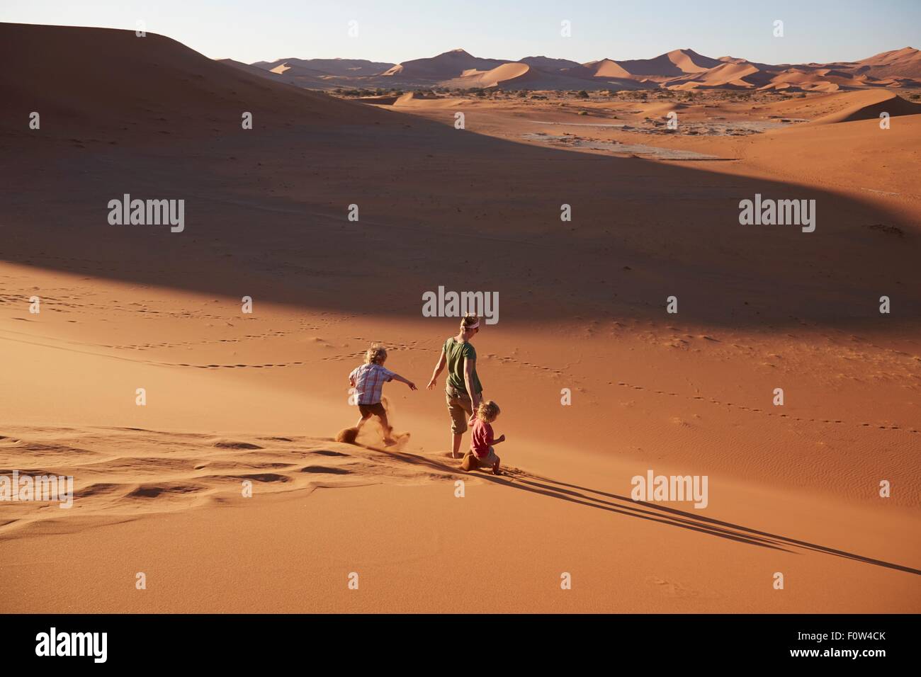 Mother and sons walking on sand dune, Namib Naukluft National Park, Namib Desert, Sossusvlei, Dead Vlei, Africa Stock Photo