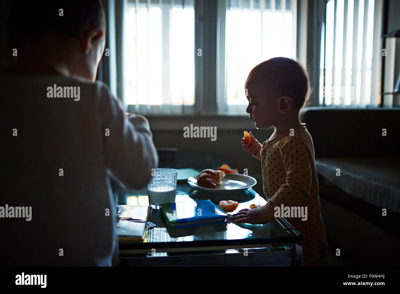 Brothers playing and eating fruits in room Stock Photo