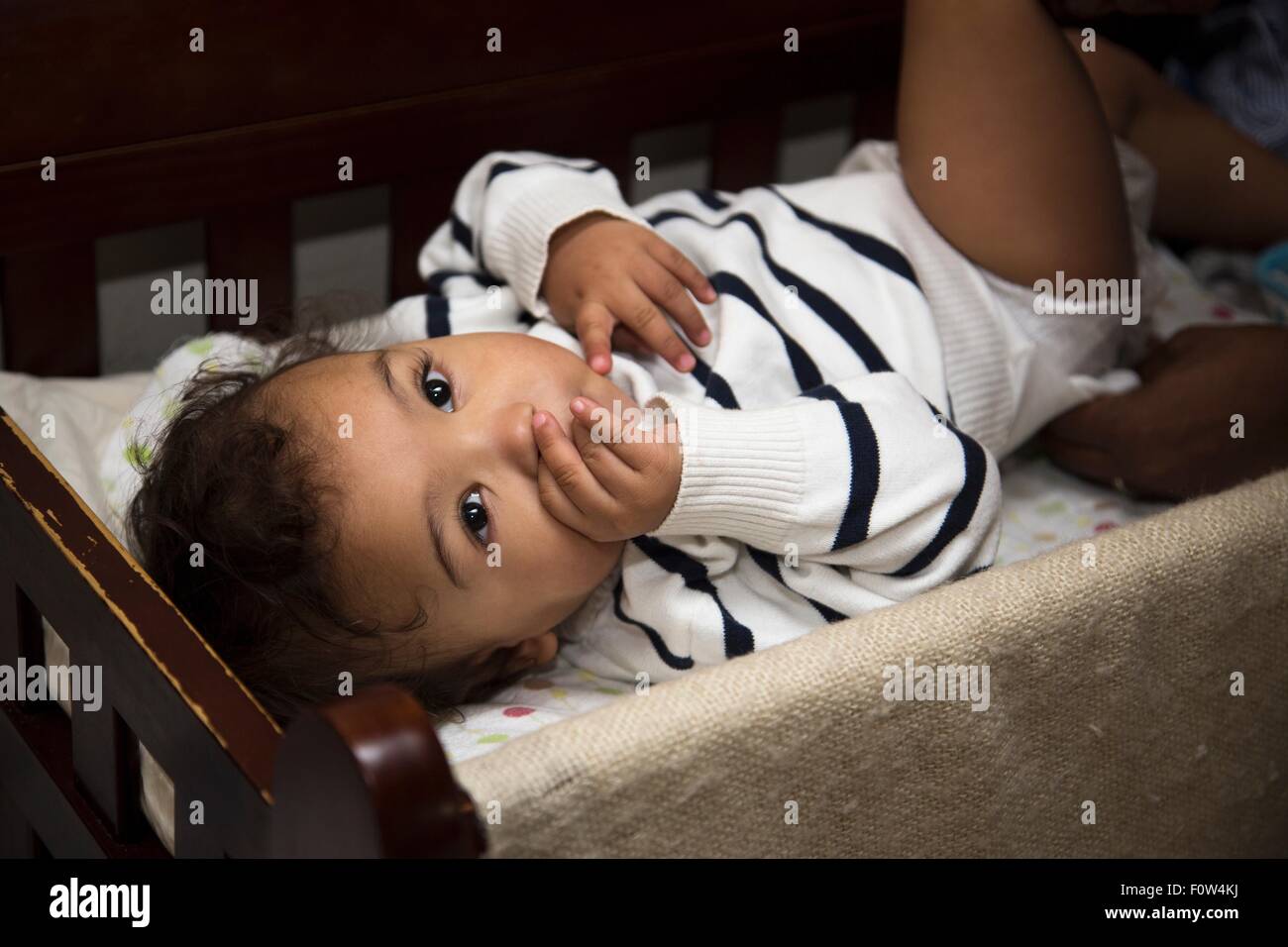 Portrait of female toddler gazing from crib Stock Photo