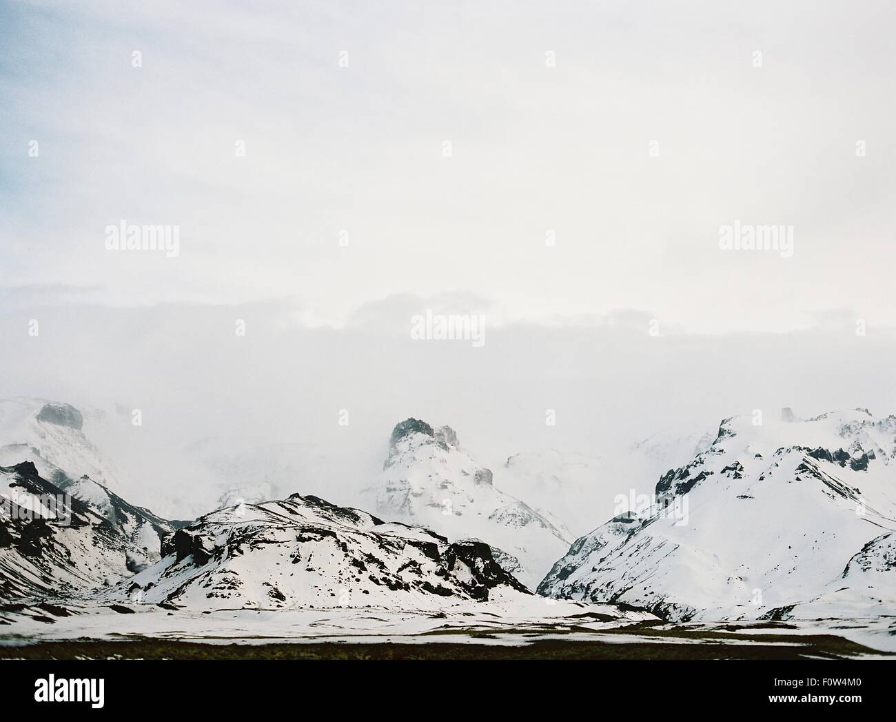 View of snow capped mountains and low cloud, Iceland Stock Photo