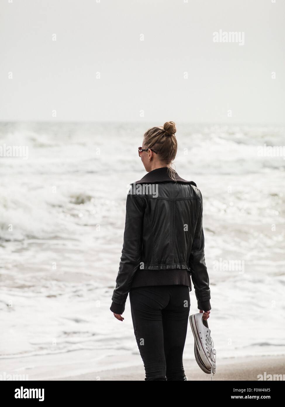 Rear view of mid adult woman looking out to sea, Torreblanca, Andalucia, Spain Stock Photo