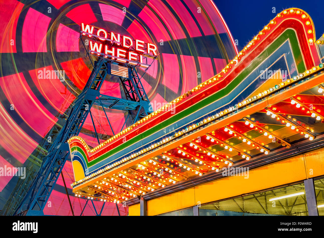 Wonder Wheel At Coney Island - Eccentric  colorful ferris wheel in motion and Illuminated amusement park marquee at the famous landmark Deno's Wonder Wheel Amusement Park at Coney Island in Brooklyn, New York. Stock Photo