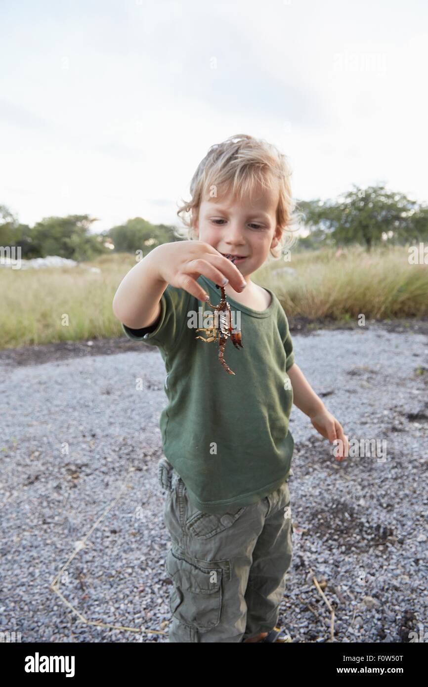 Portrait of young boy holding scorpion, Otavi, Etosha, Namibia Stock Photo