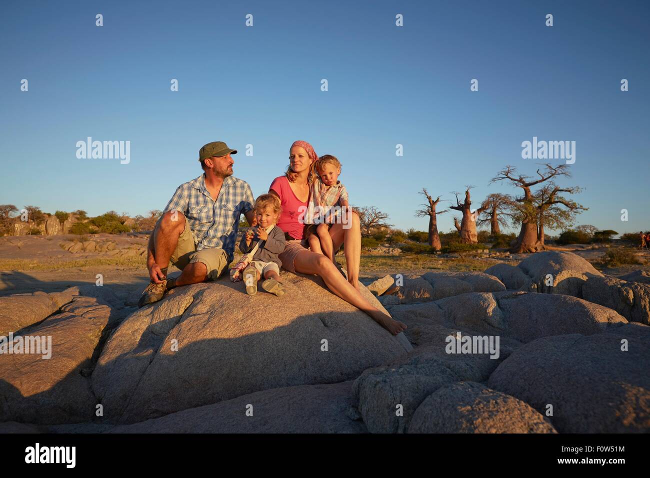 Family sitting on sitting on rock, looking at view, Gweta, makgadikgadi, Botswana Stock Photo