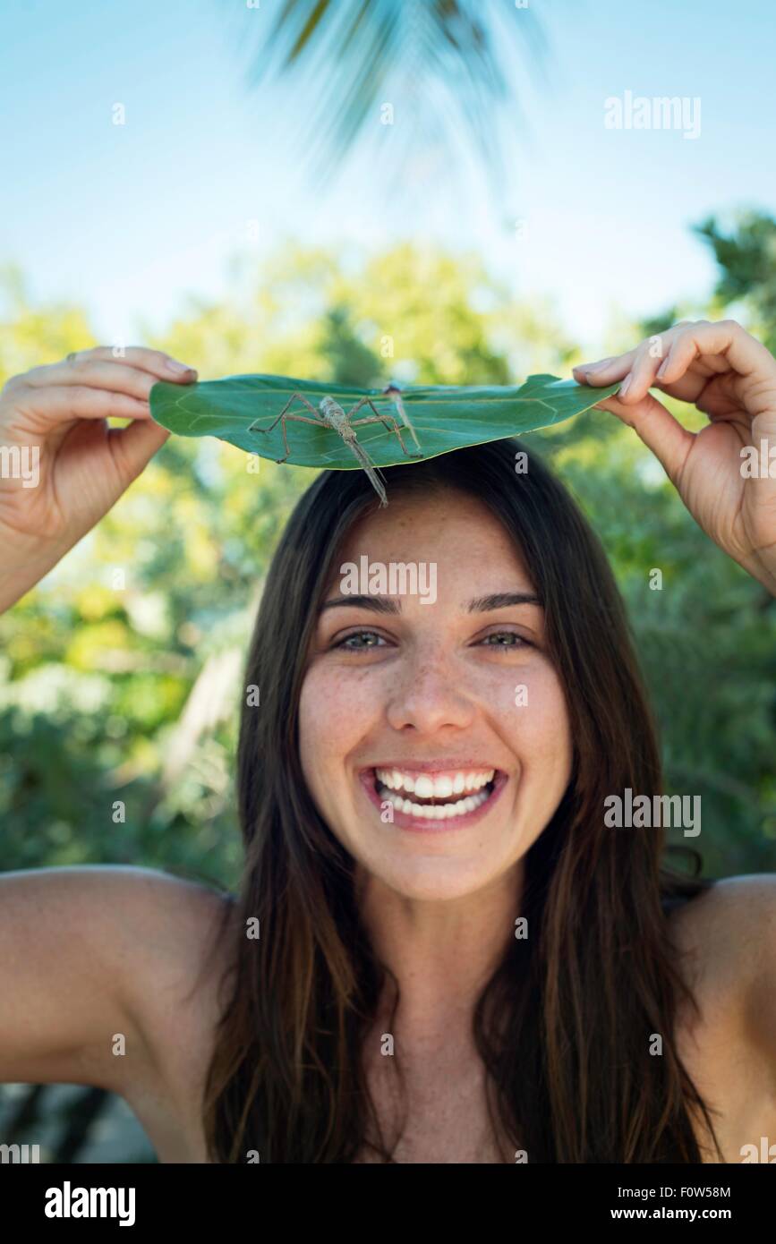Portrait of young woman with leaf and insect on top of head, Islamorada, Florida, USA Stock Photo