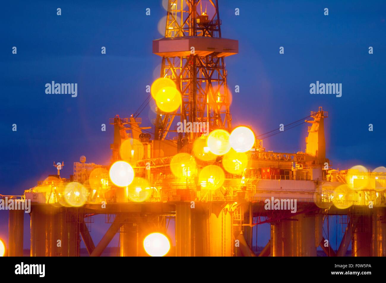 Blurred view of illuminated drilling rig at night Stock Photo