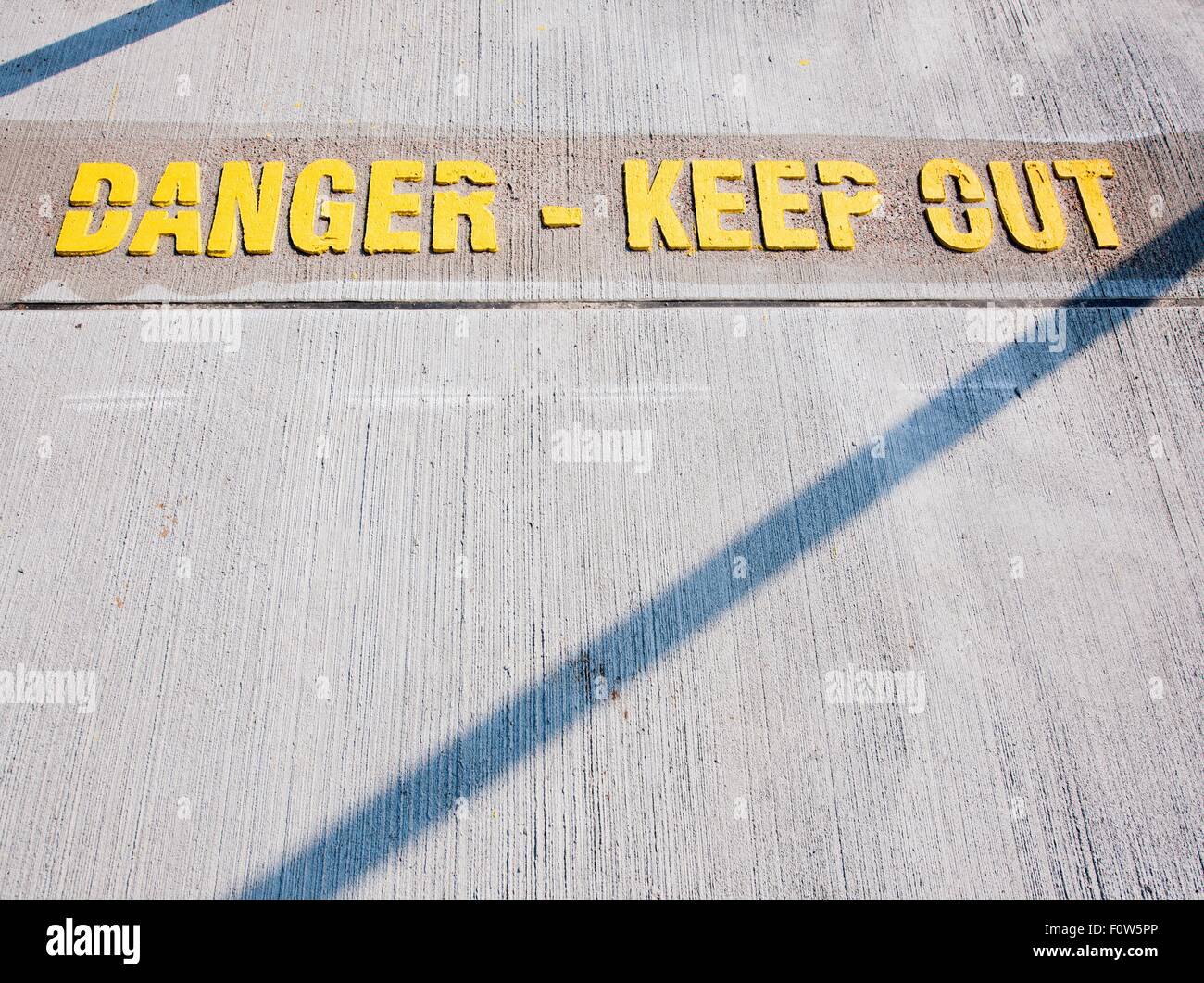 Danger - keep out warning sign on concrete floor Stock Photo