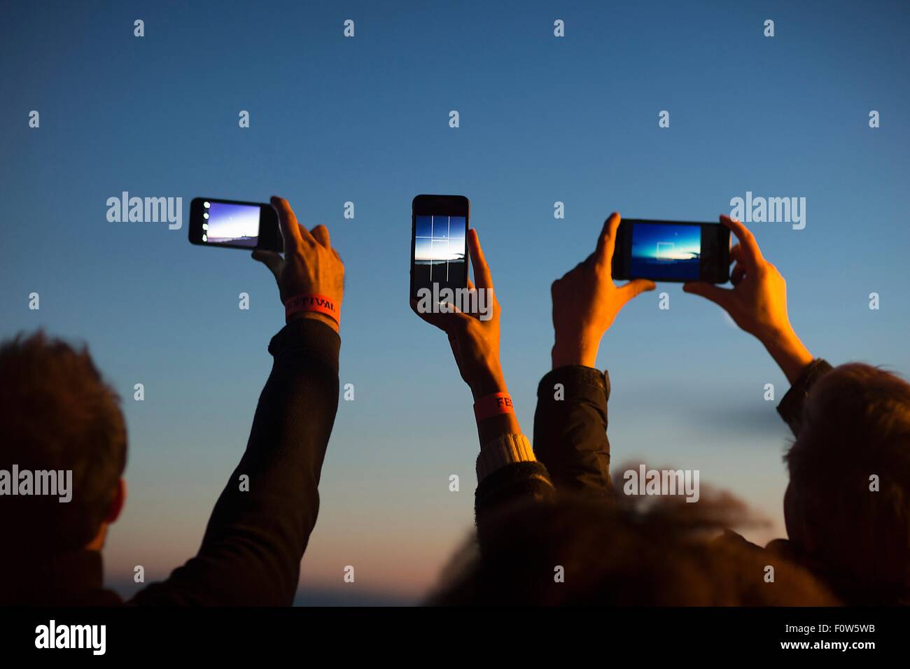 Friends taking photograph with smartphone at dusk Stock Photo
