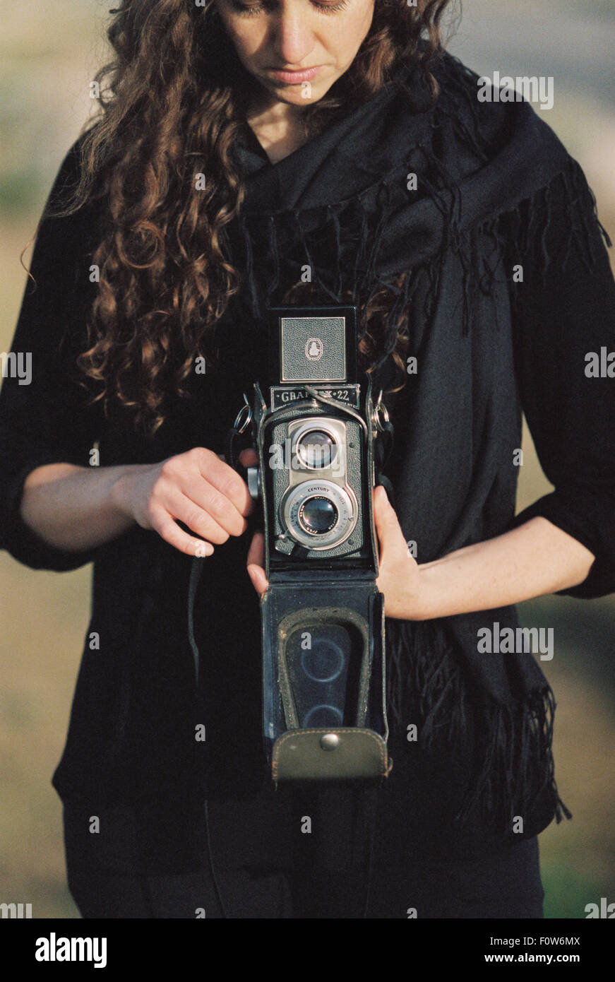 A woman taking a picture with an old fashioned medium format camera. Stock Photo