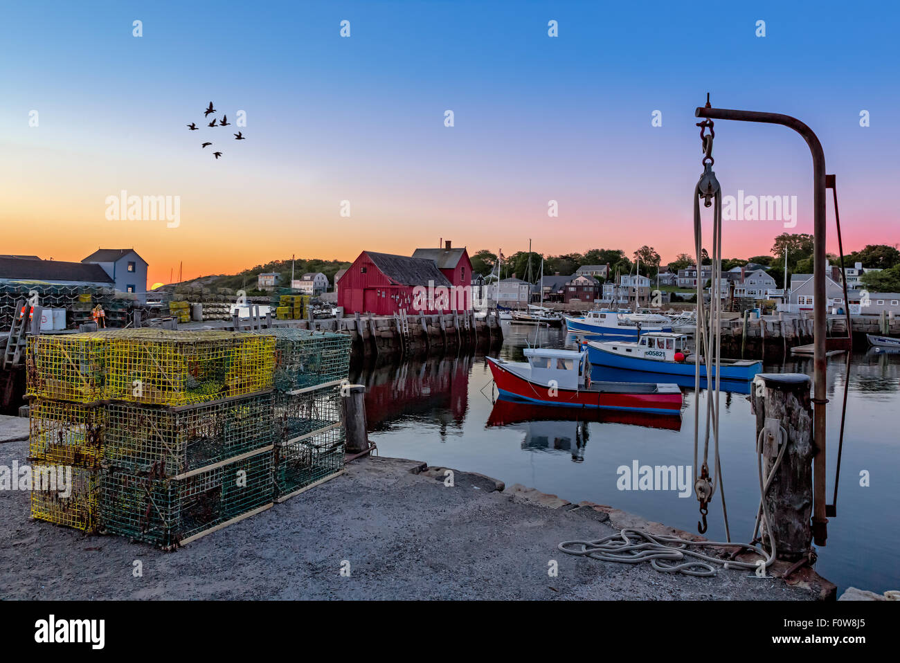 The quintessential New England Motif Number One sunrise. Located on Bradley Wharf in the harbor town of Rockport. Motif Number One has been a long time favorite subject for artist, due to its location, lighting, composition as well as it being a symbol of New England maritime life. Stock Photo