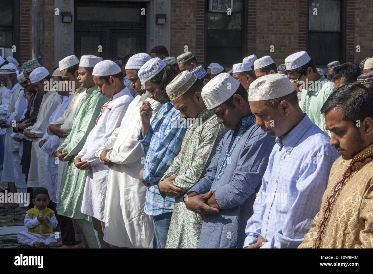Muslims pray outside a mosque in Kensington, Brooklyn, NY for 'Eid al-Fitr.' The holiday,celebrated around the world, marks the Stock Photo