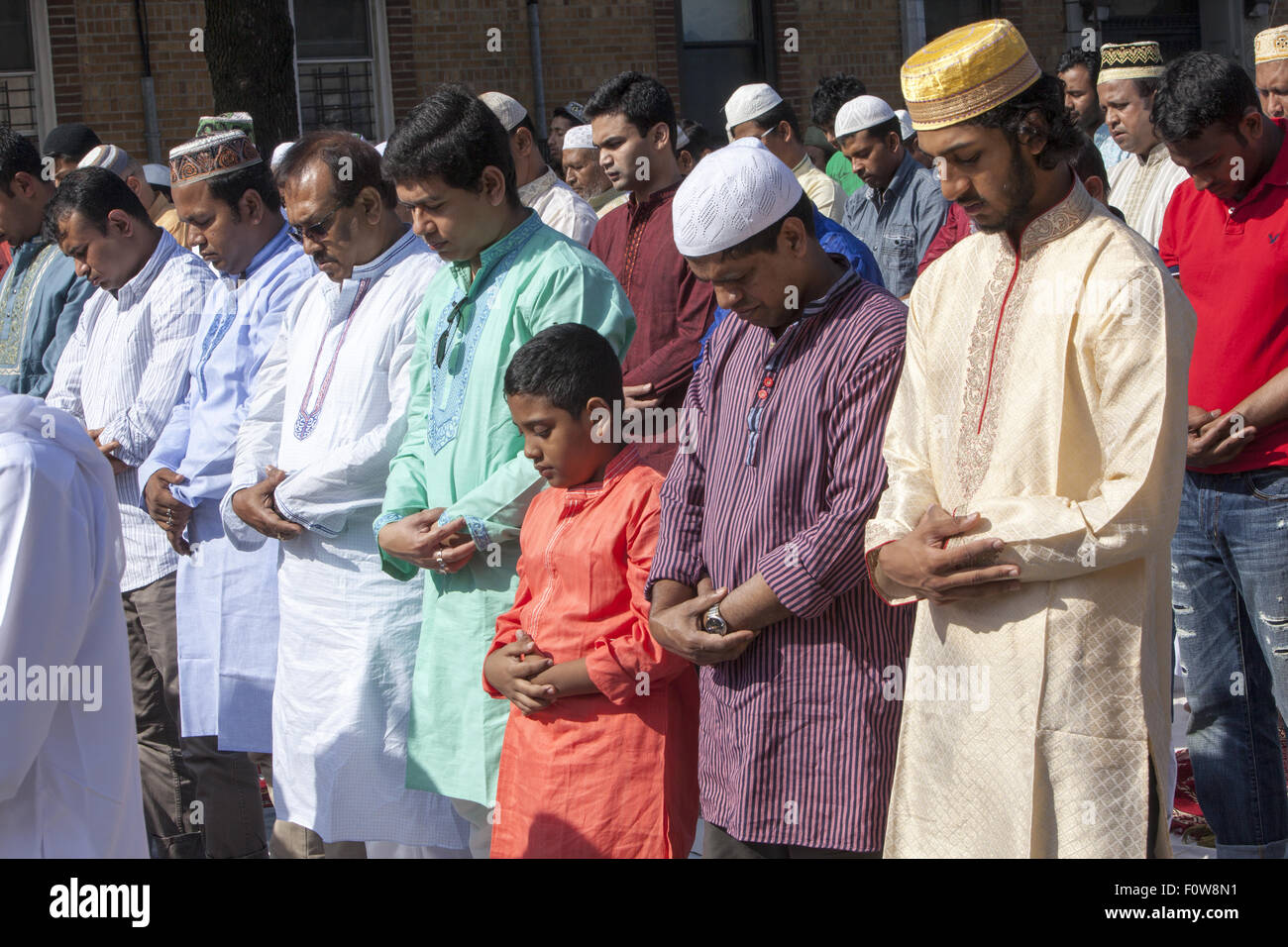 Muslims pray outside a mosque in Kensington, Brooklyn, NY for 'Eid al-Fitr.' The holiday,celebrated around the world, marks the Stock Photo