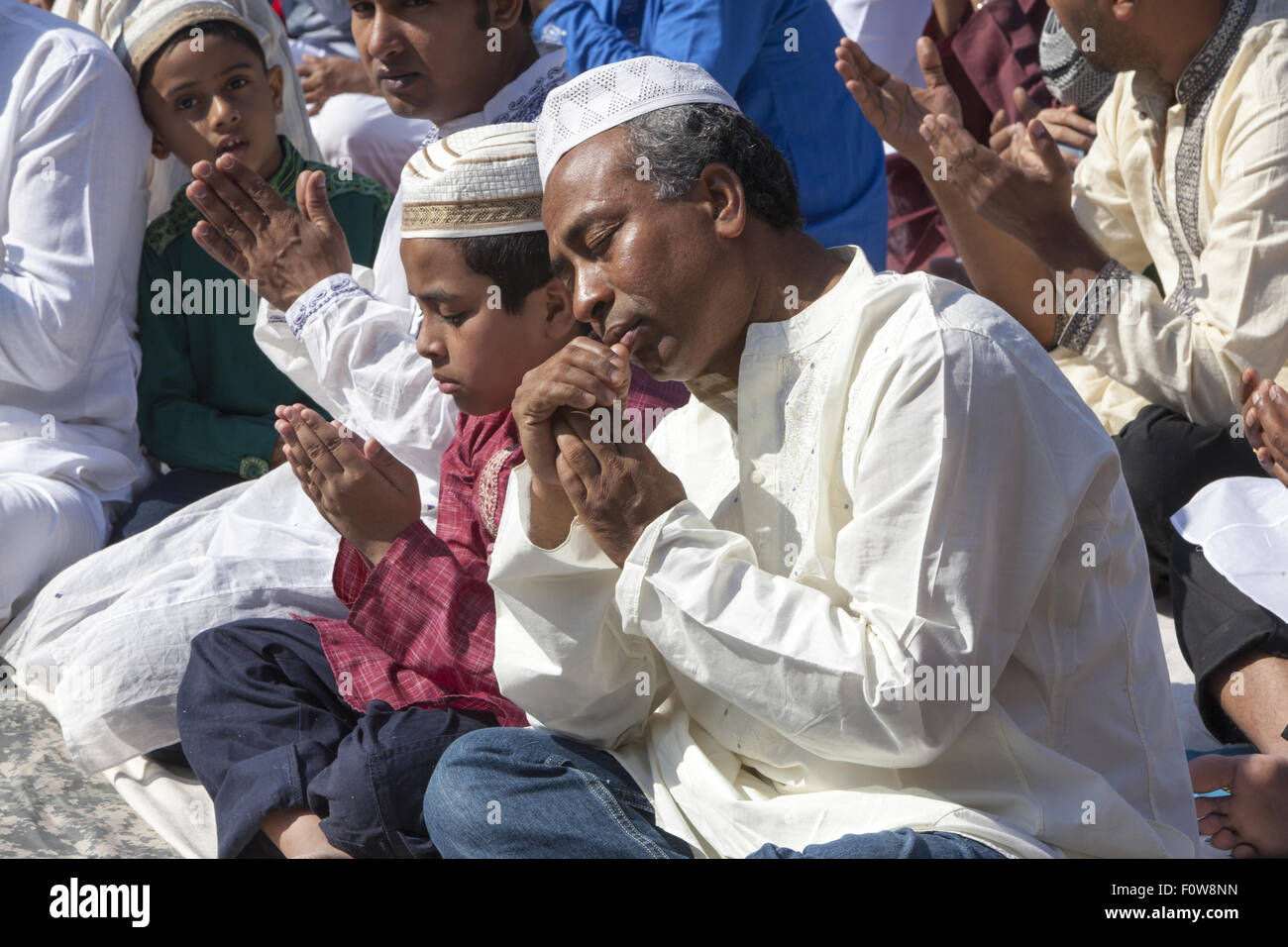 Muslims pray outside a mosque in Kensington, Brooklyn, NY for 'Eid al-Fitr.' The holiday, celebrated around the world, marks the Stock Photo