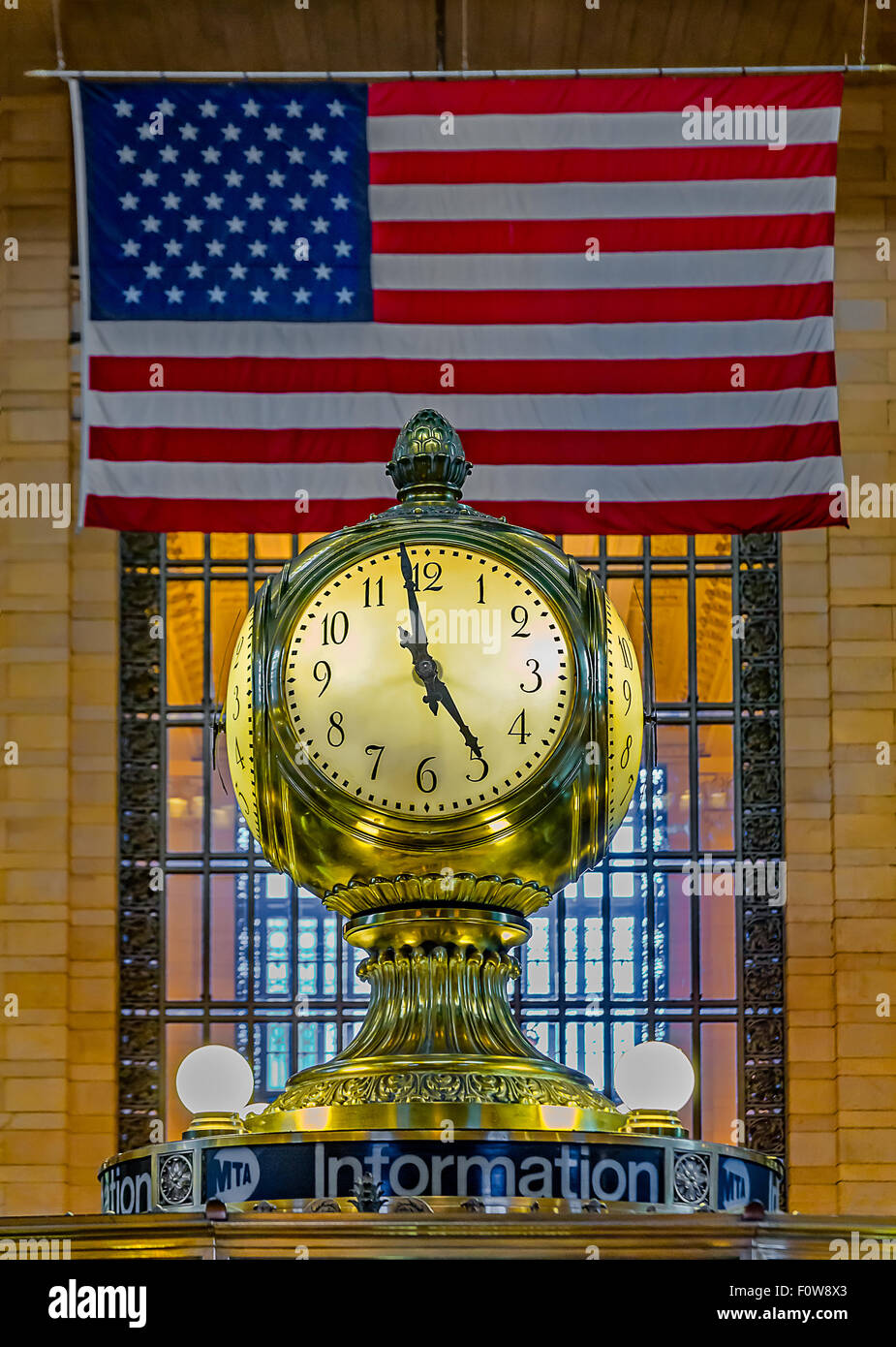 Opal Clock at the information booth in the main terminal at Grand Central Terminal, with the American Flag in the background. Stock Photo