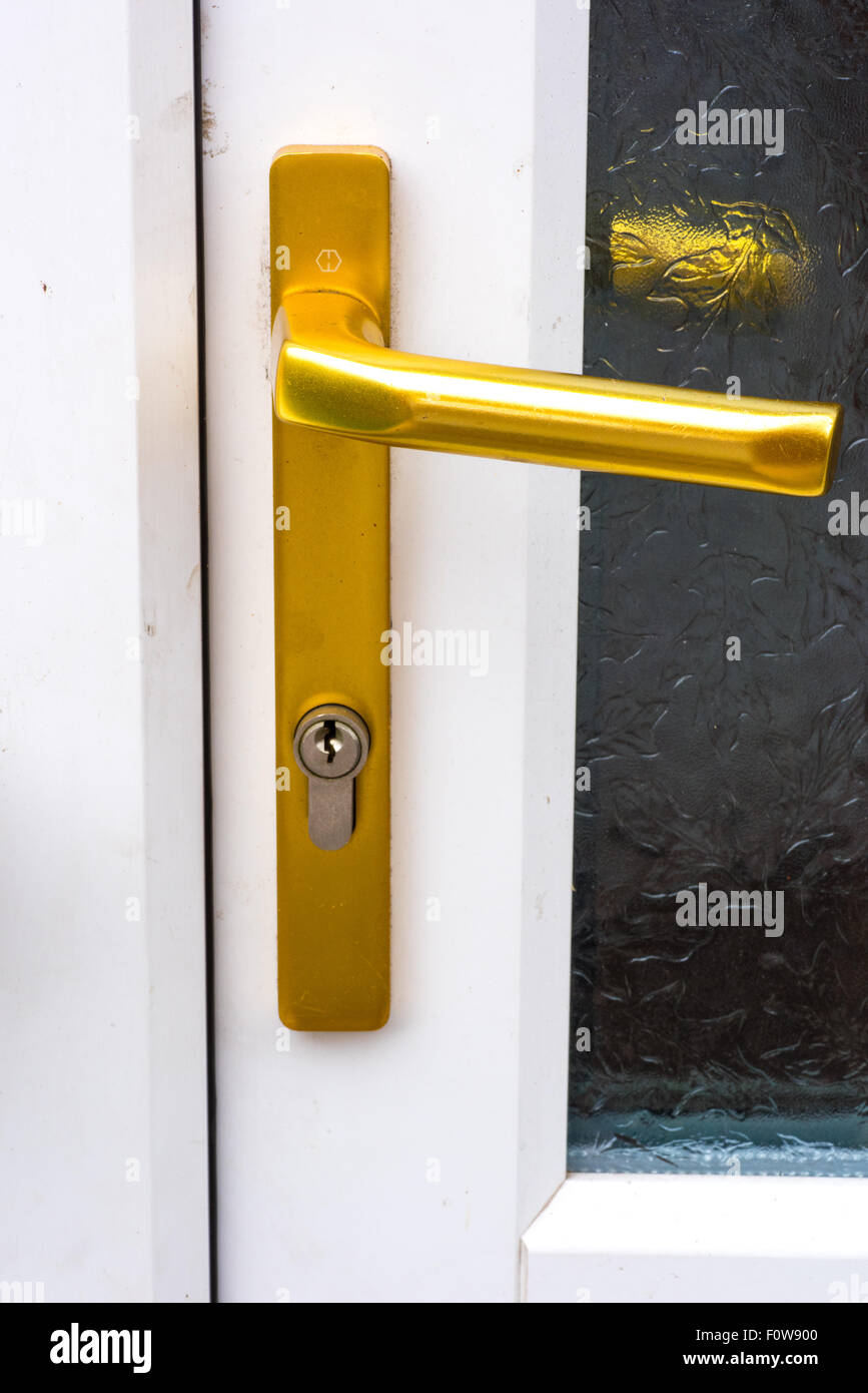 A gold door handle on a double glazed door Stock Photo - Alamy