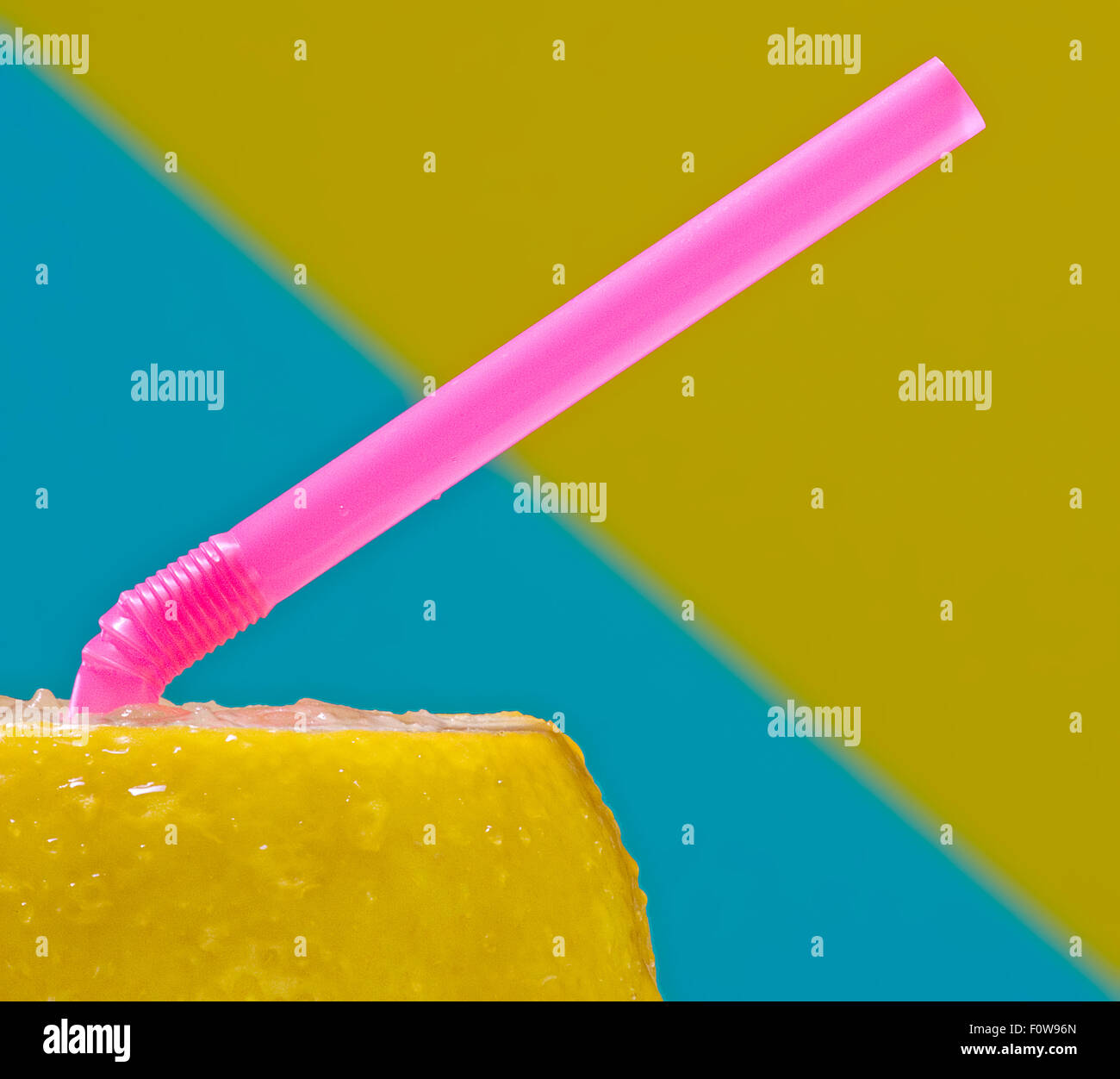 Closeup of a lemon with a pink straw. Stock Photo