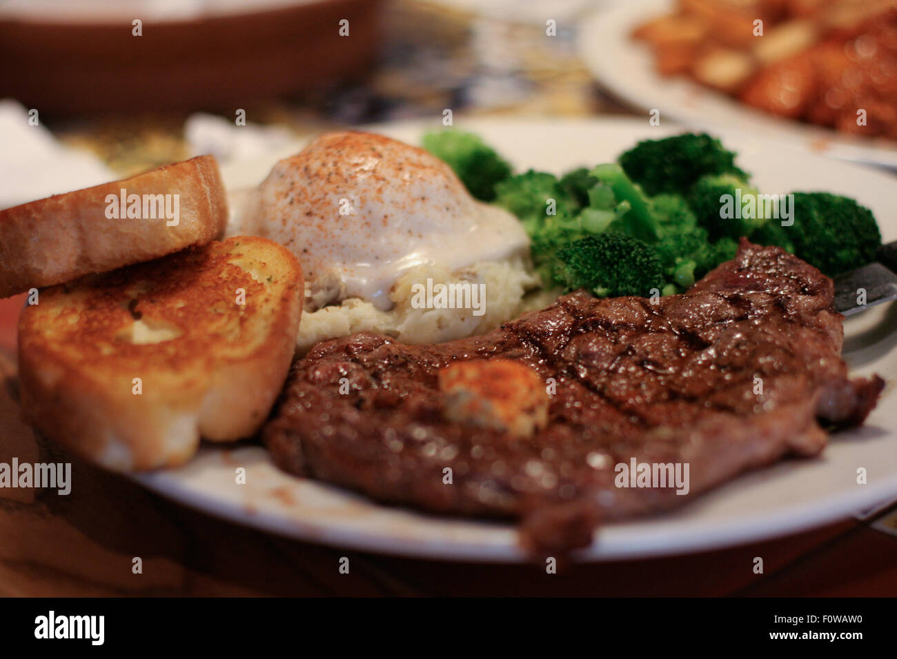 Plate of steak mashed potatoes garlic bread and broccoli Stock Photo