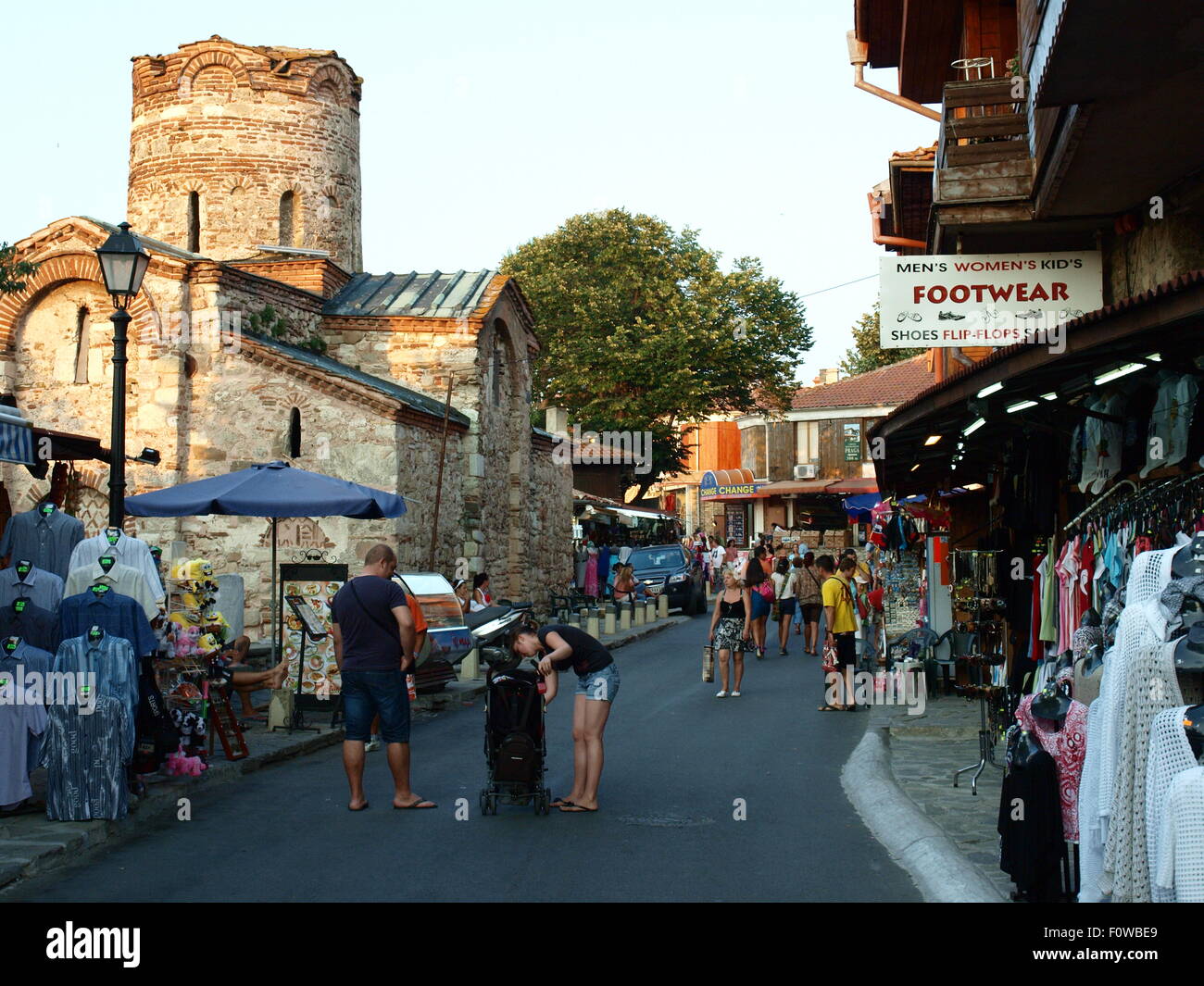 Bulgaria, Nessebar. Shops with folk products and souvenirs in a stylish wooden houses. On the back is a medieval church. Stock Photo