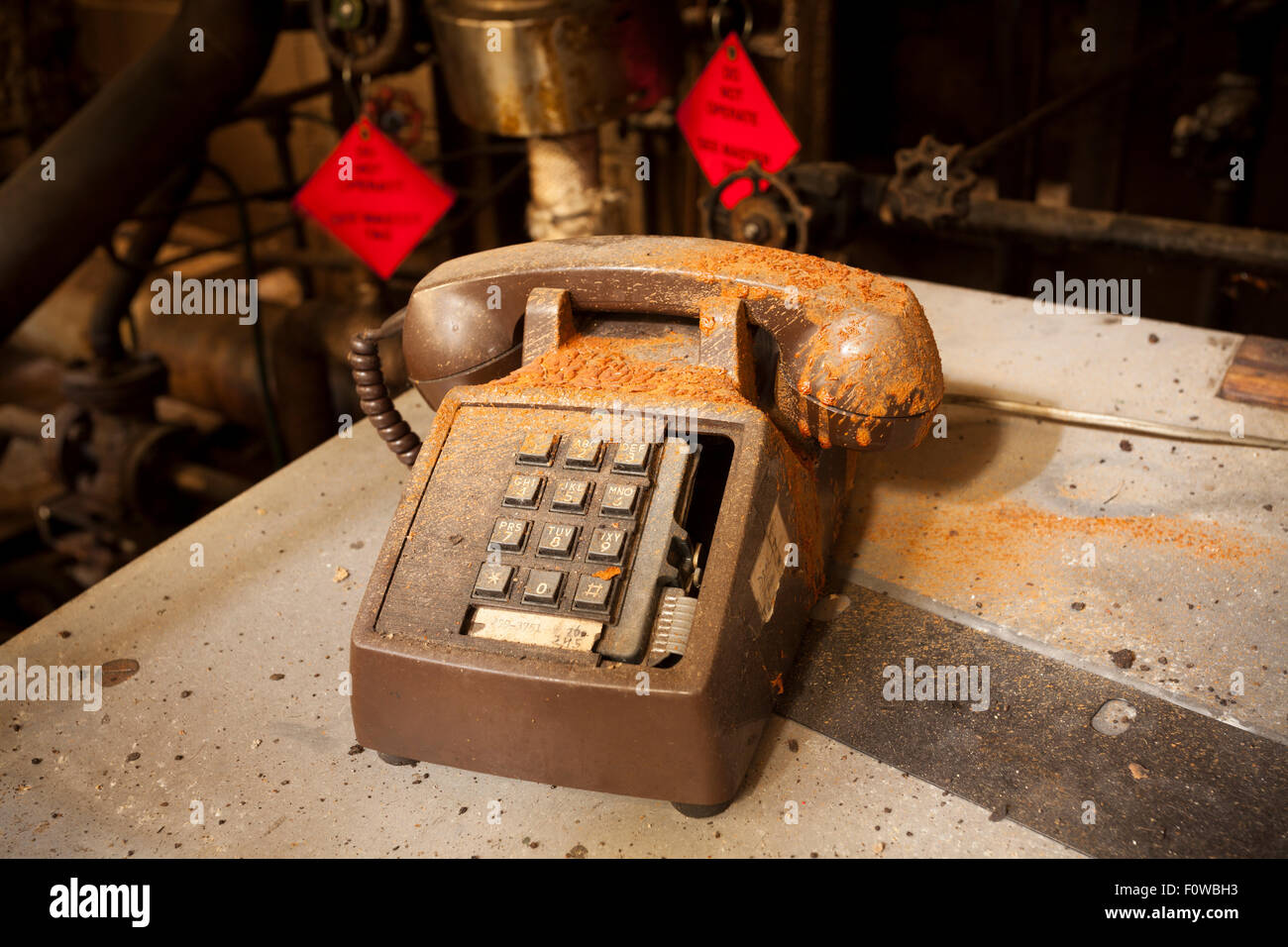 A filthy broken telephone covered in dust and industrial chemicals. Stock Photo