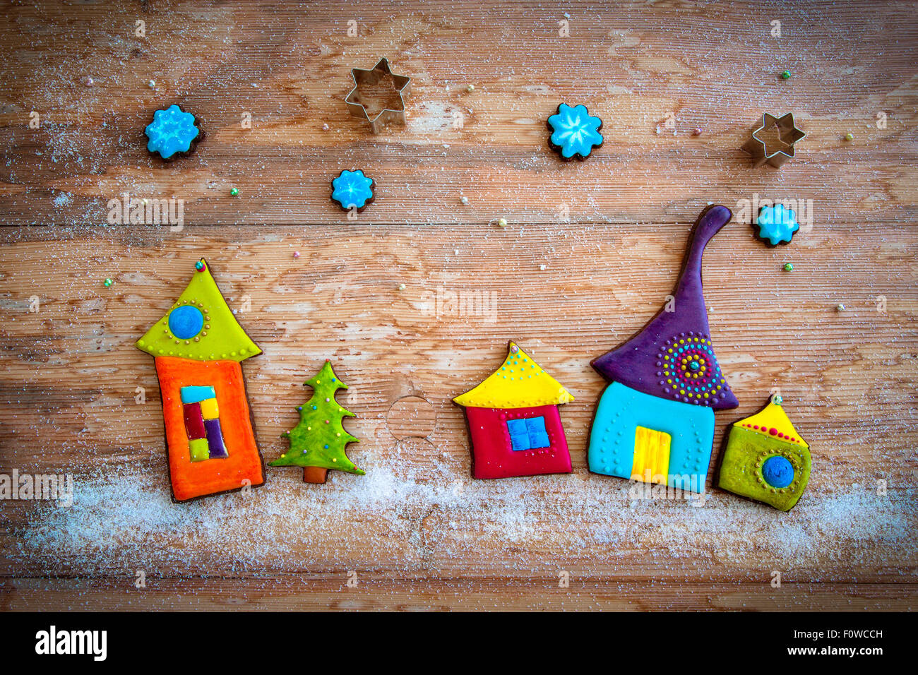 homemade cookies decorated with royal icing: colorful christmas village on wooden background Stock Photo