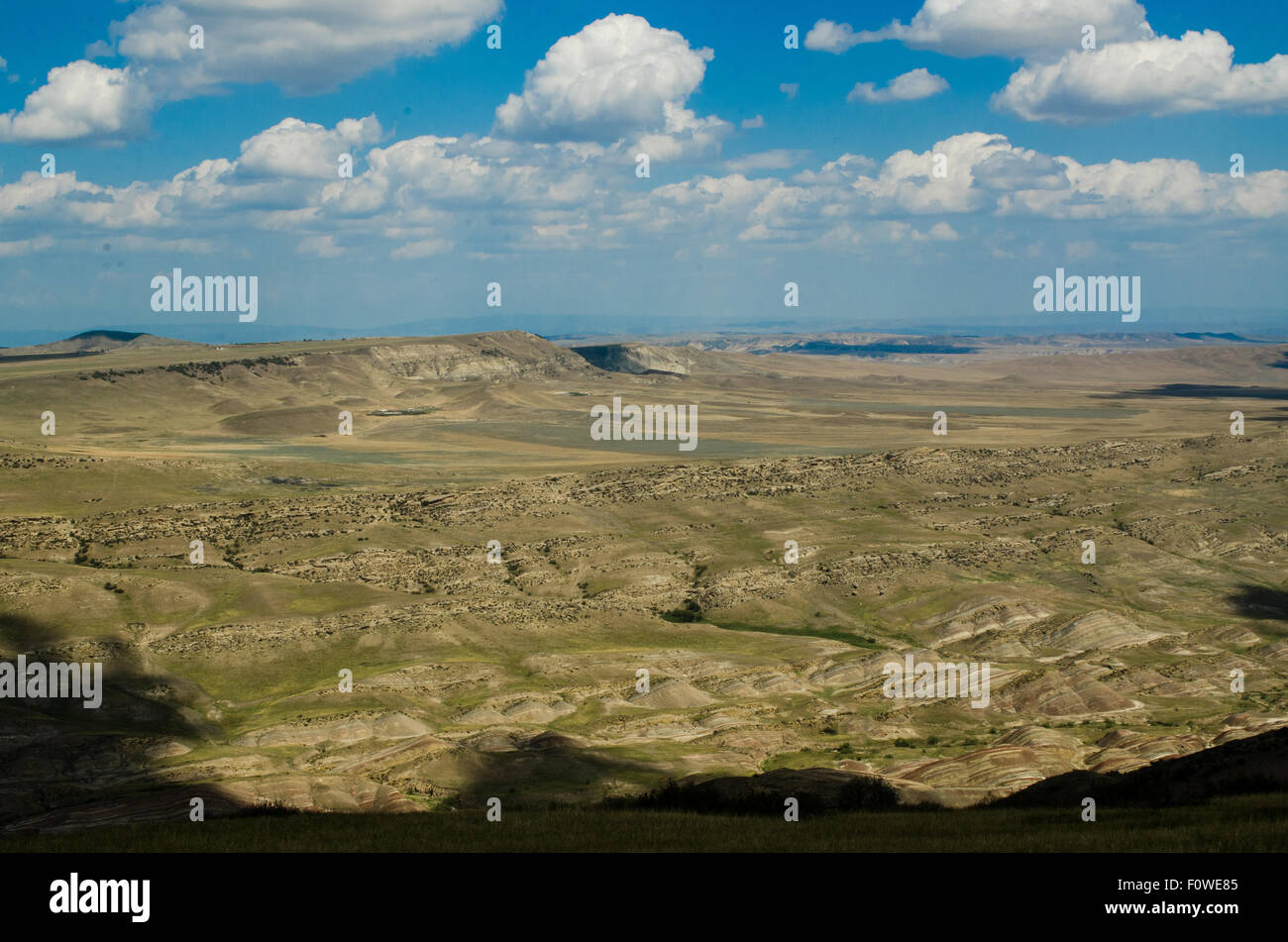 Scenic view of rolling hills and clouds under a bright blue sky in a ...