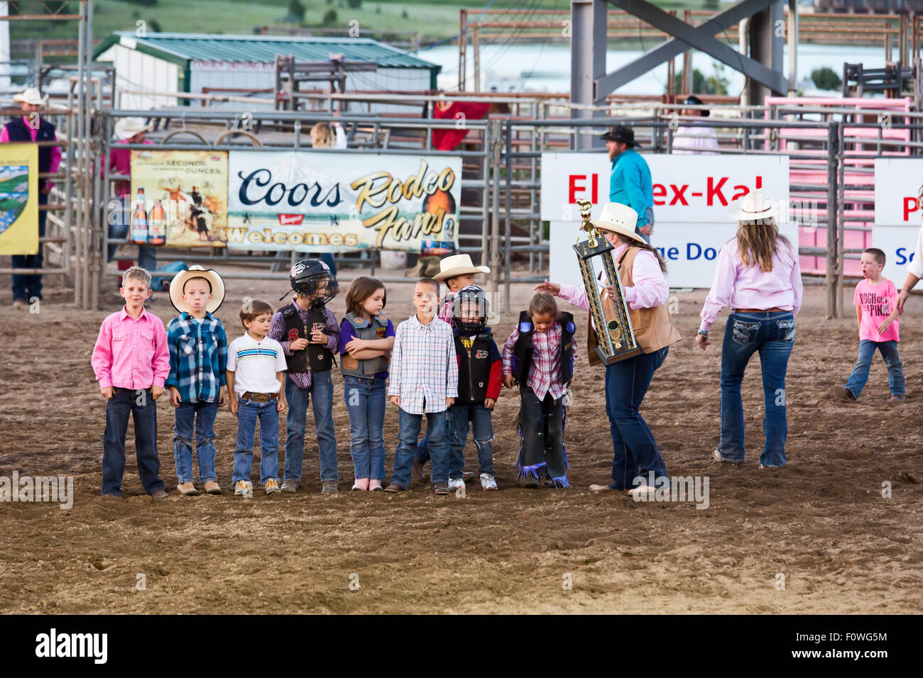 Estes Park, Colorado - An official at the Rooftop Rodeo holds a trophy for the Mutton Bustin' winner. Stock Photo