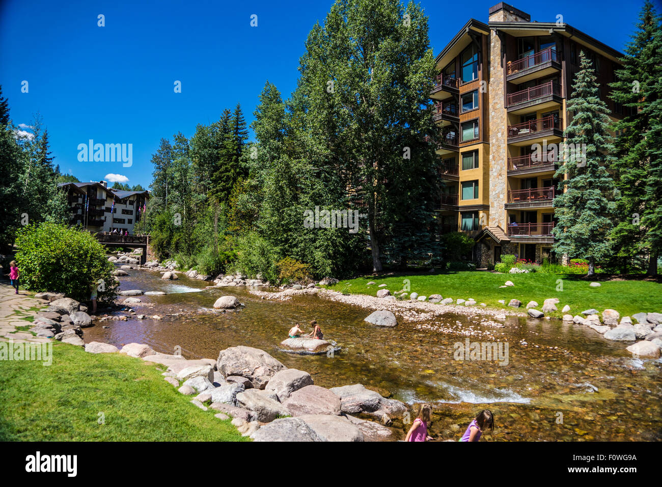 Gore Creek In Vail Colorado during summer with kids playing in stream Stock Photo