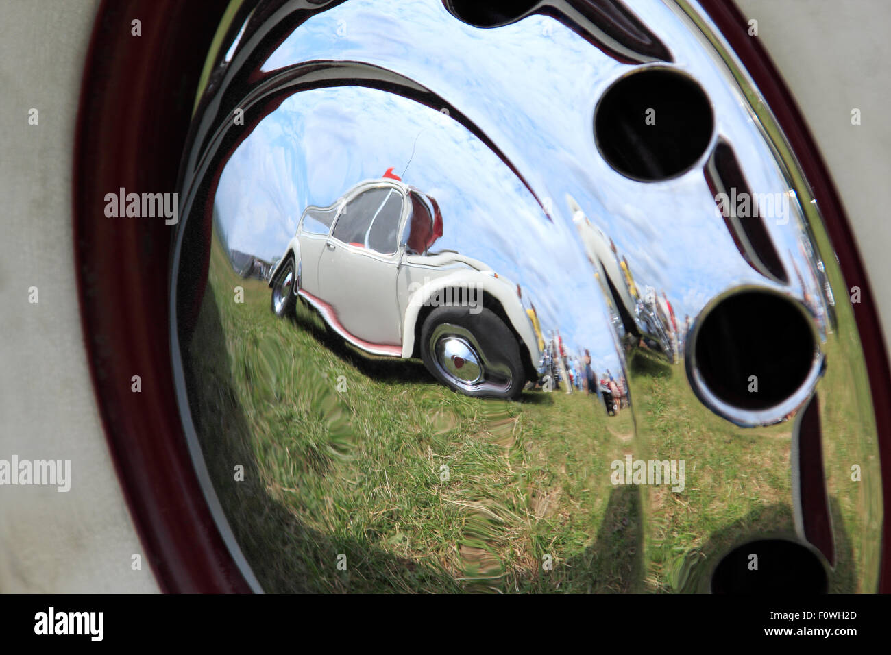 Vintage car reflected in a chrome hubcap. Stock Photo