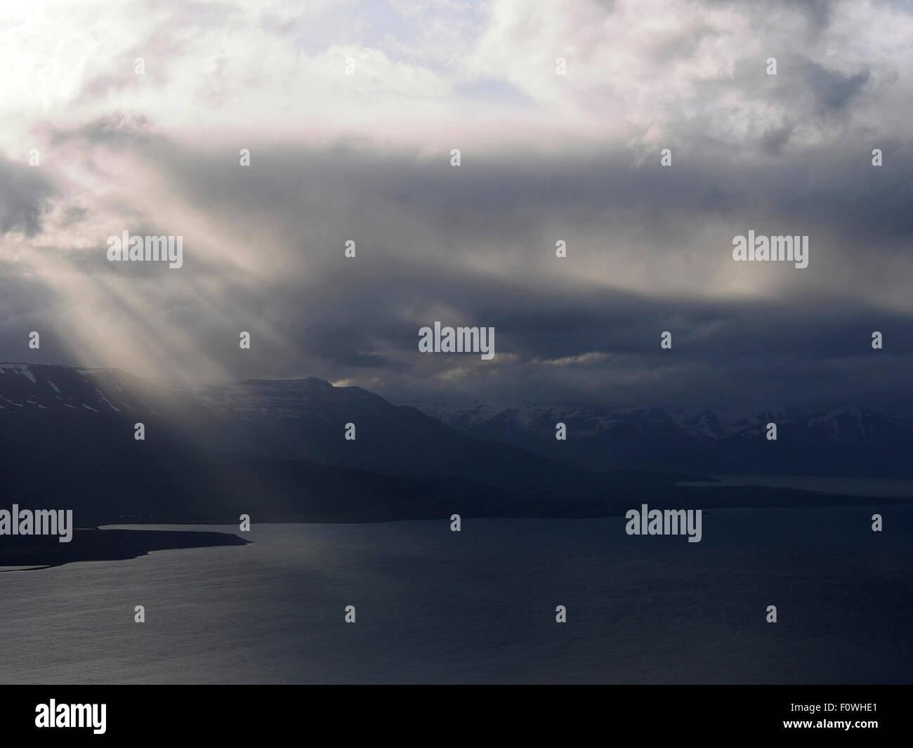 shafts of light breaking through clouds over Eyjafjörður from Ystuvíkurfjall, near Akureyri Iceland Stock Photo