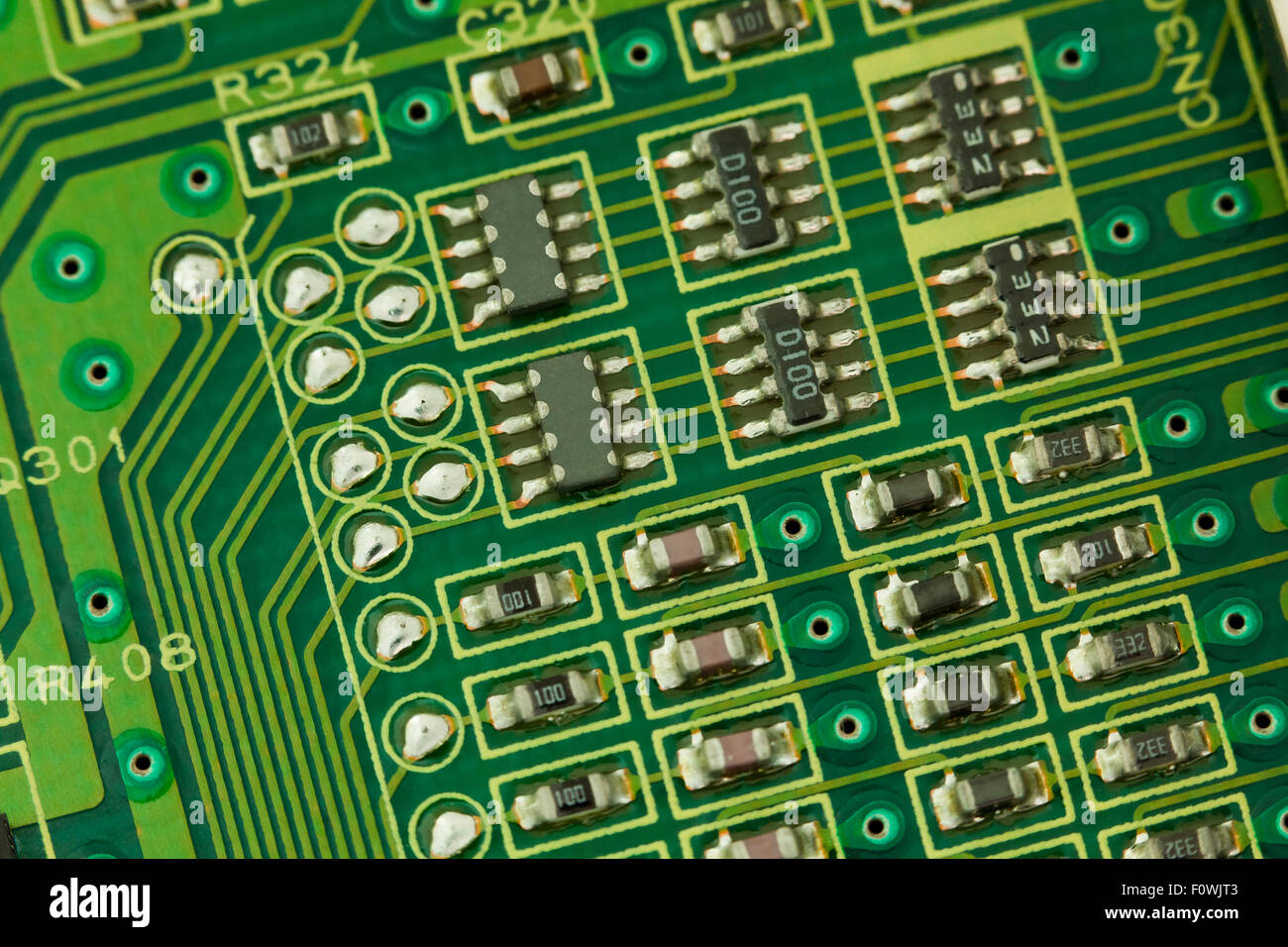 Circuit board components closeup showing conductive traces, micro IC chips, micor transistors, and micro resistors Stock Photo