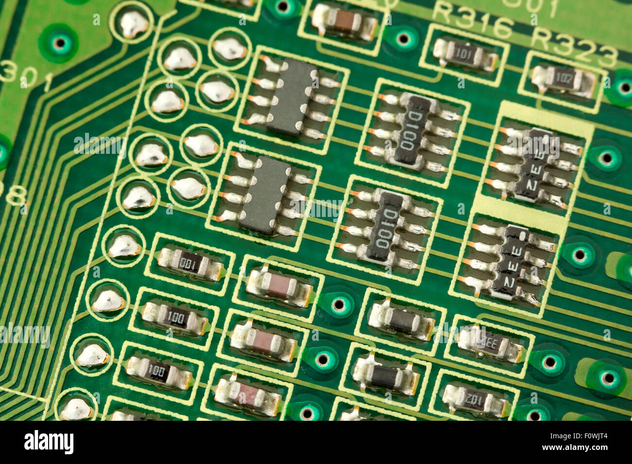 Circuit board components closeup showing conductive traces, micro IC chips, micor transistors, and micro resistors Stock Photo