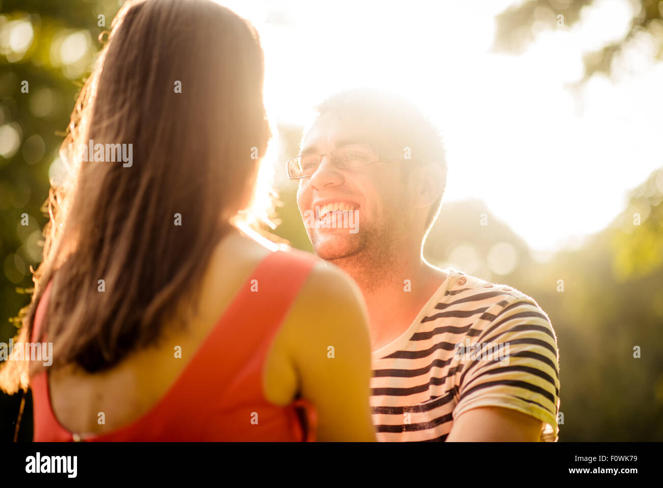 Young happy couple sitting on grass in nature and talking Stock Photo ...