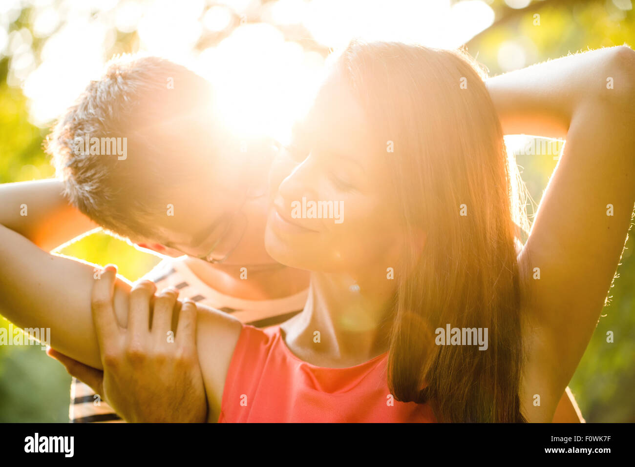 Romantic young couple embracing and kissing at sunset in nature Stock ...