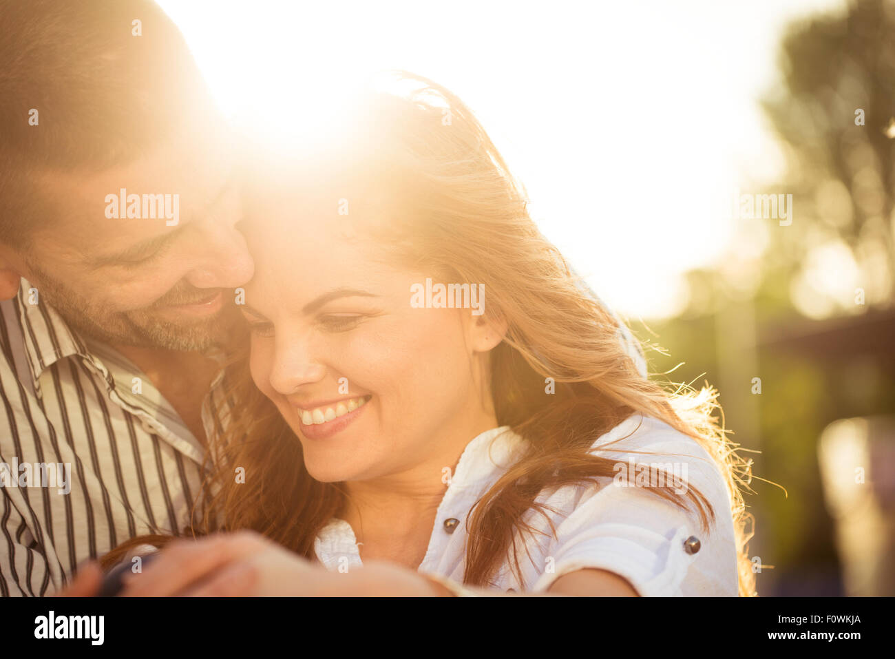 Happy couple having great time together - photographed at sunset against sun Stock Photo