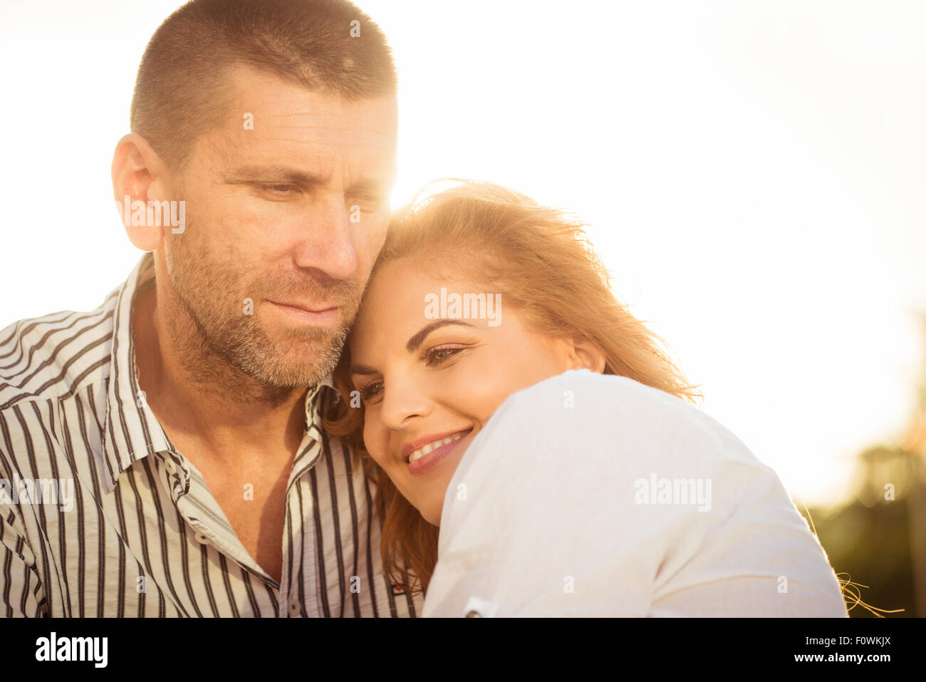 Romantic couple hugging outdoor - woman on man's shoulder Stock Photo