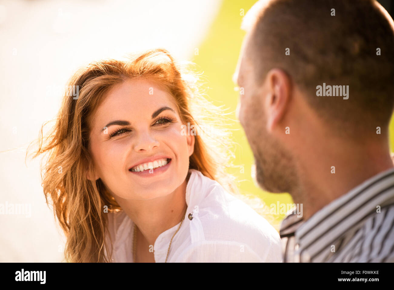 Smiling young woman looking to eyes of her man on date outdoors Stock Photo