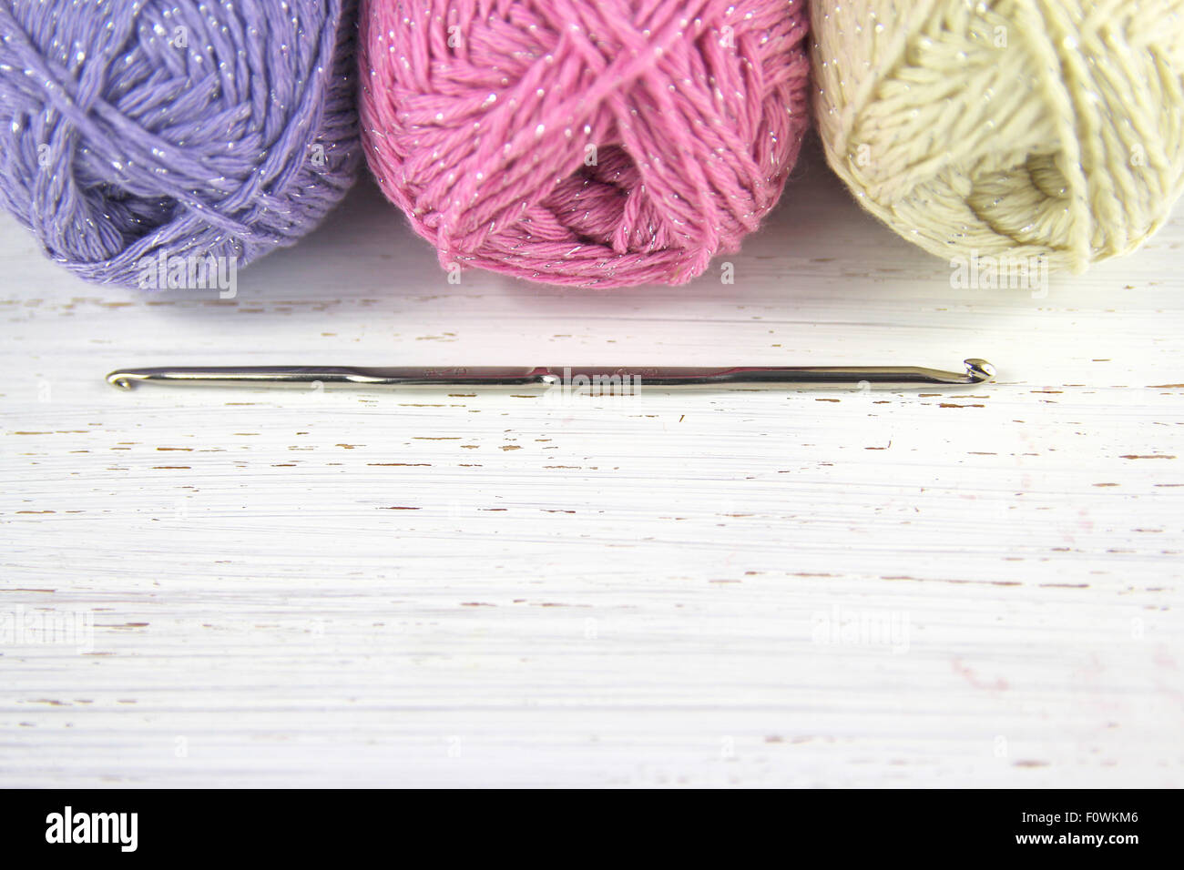 Yarn Wool pastel colours with crochet hook and copy space on distressed wood background Stock Photo