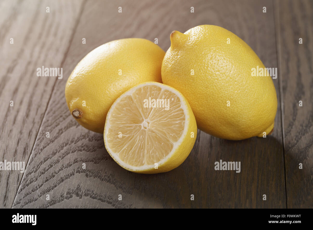 fresh ripe lemons sliced on wood table Stock Photo - Alamy