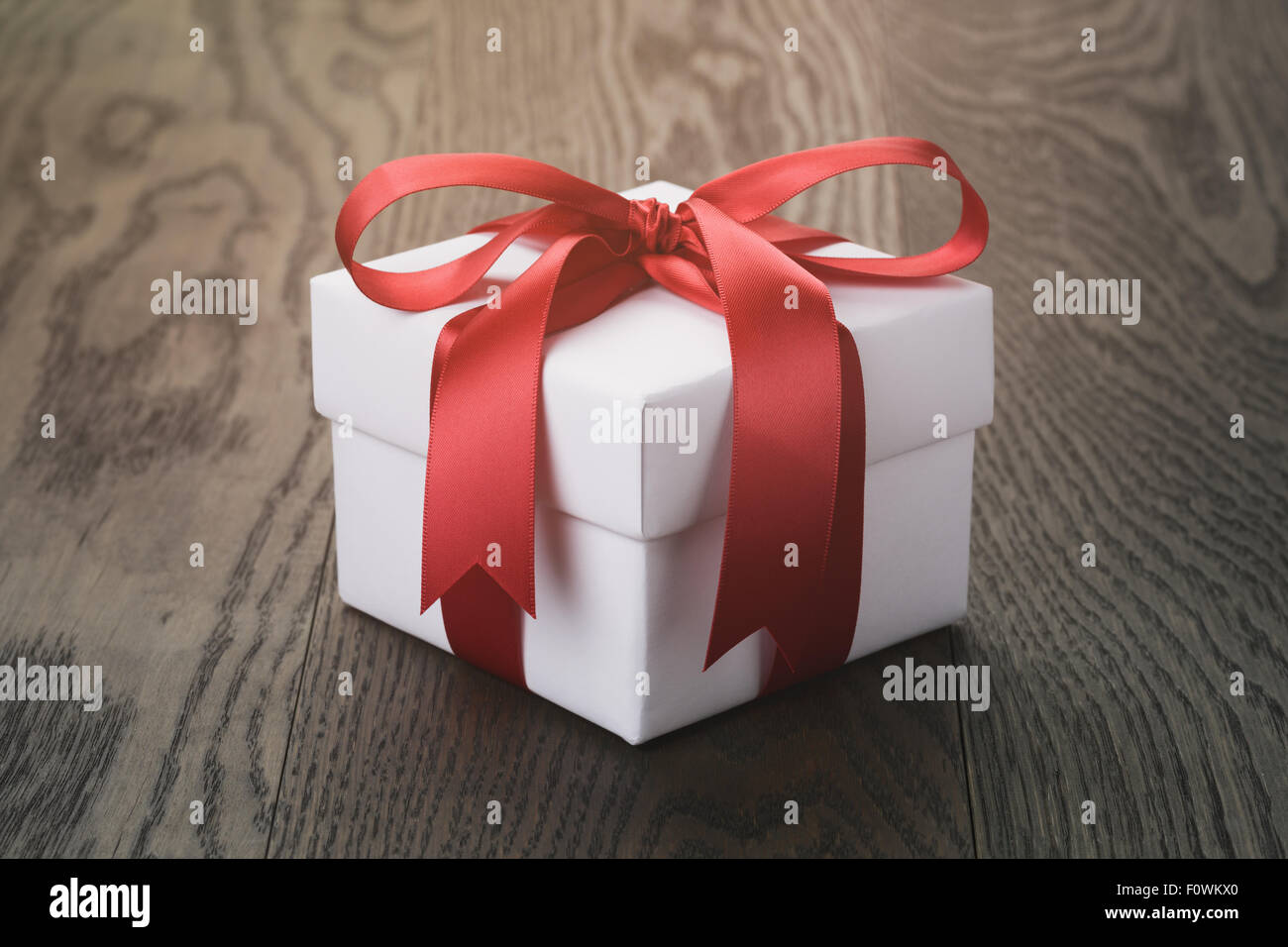 gift box with red bow on rustic table Stock Photo