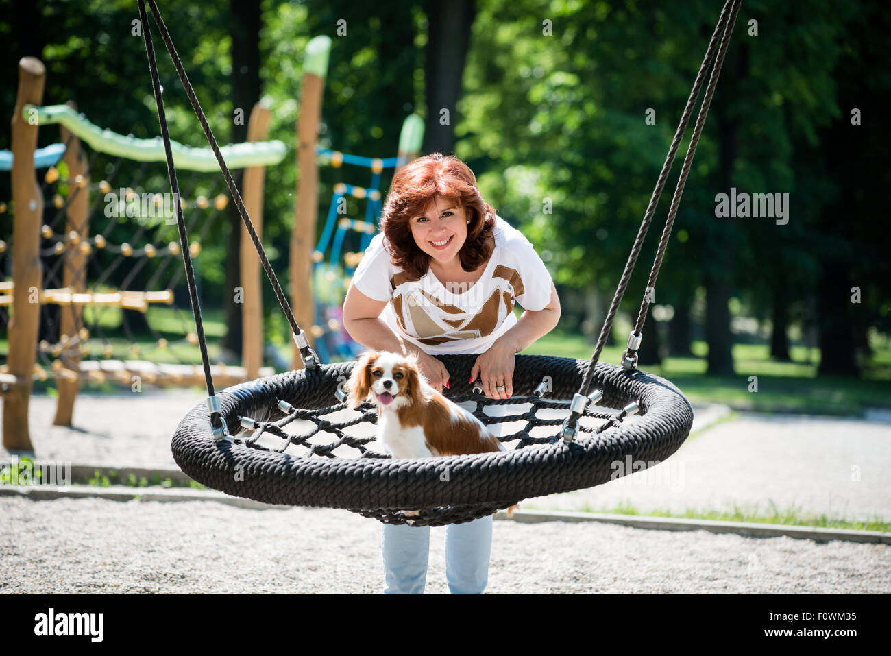 Mature woman swinging in park hi-res stock photography and images - Alamy