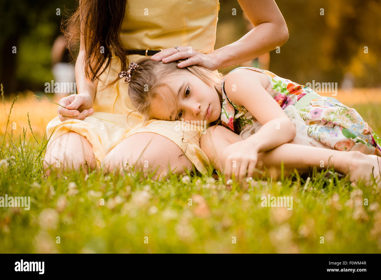 Mother is caressing her worried child outdoor in nature Stock Photo