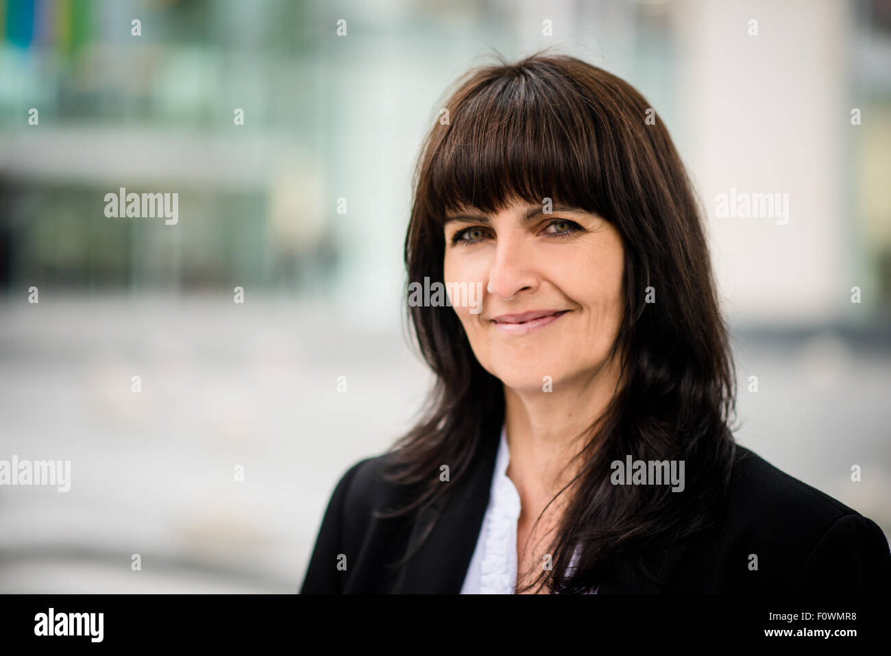 Portrait of smiling confident senior business woman in a street Stock ...