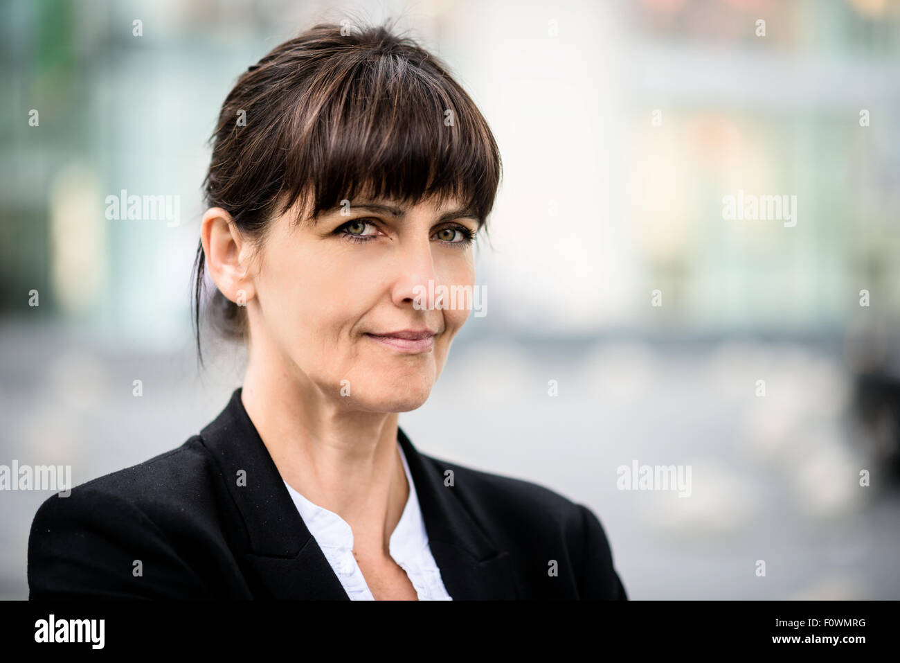 Portrait of smiling confident senior business woman in a street Stock Photo